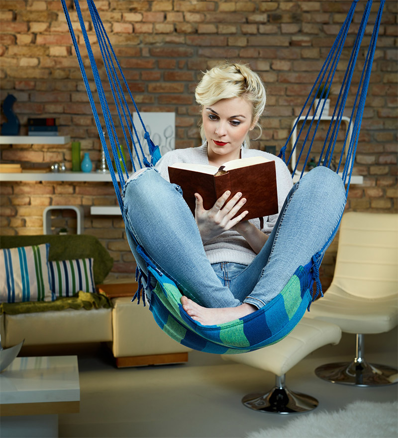 Woman Reading in Front of Brick Wall